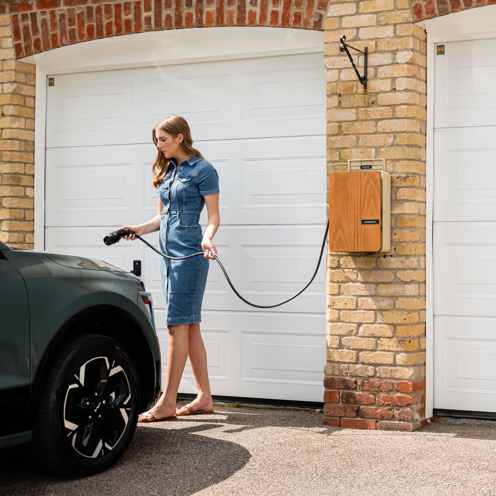 Driver plugging an electric car into a wall-mounted home charger